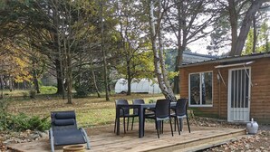 A wooden deck with outdoor furniture, a small table, and chairs. - In a stunning location with a beautiful ocean view; the beach is just 1 minute away (Pénestin)
