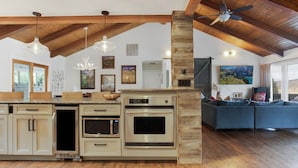 A spacious kitchen with a large island, built-in ovens, and a dining area with a blue sofa. - Vail mountain house! 5 bedrooms plus loft.  Hot tub! (Vail)