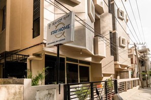 Um edifício com uma placa 'Stay Home Classic', um número de contato e uma placa 'VTC-821'.