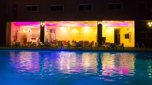A hotel pool area with lounge chairs and a clock on the wall. - Hôtel du Golfe (Lomé)