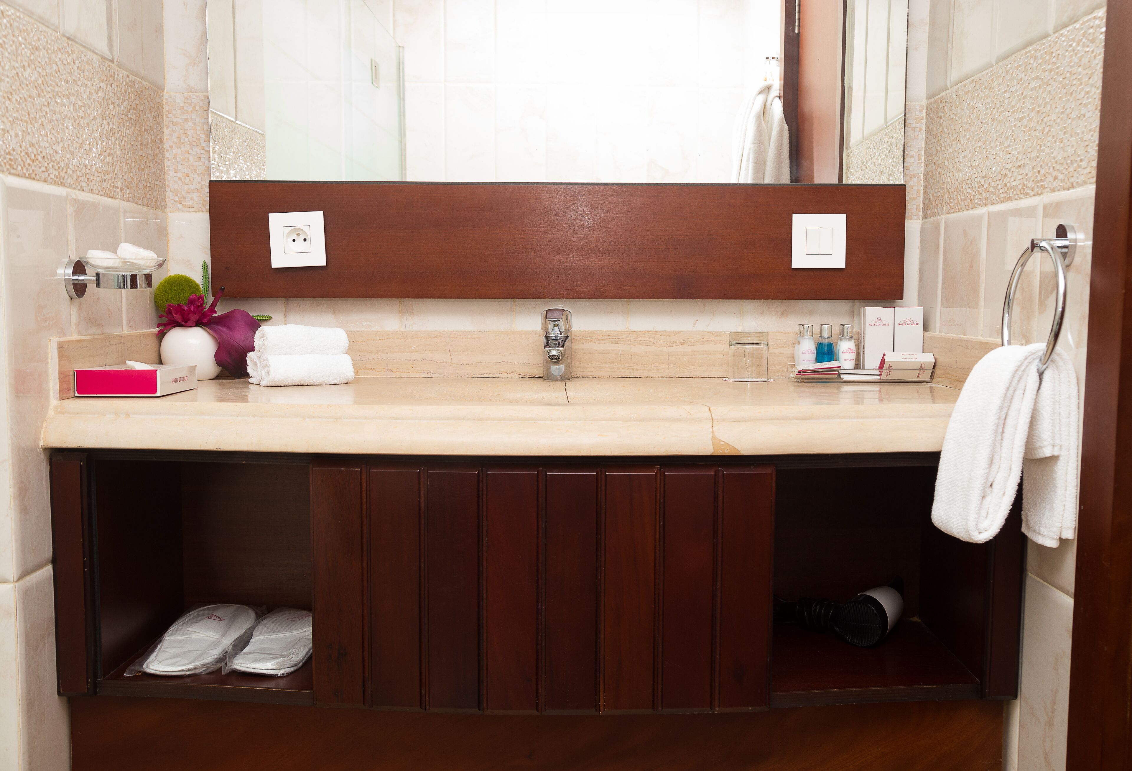 A modern bathroom with a large mirror, a sink, and a vanity with storage cabinets.