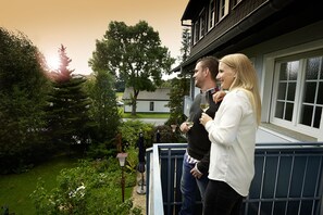 A balcony with a view of a garden and a house. - Kucher's Genuss & Businesshotel (Darscheid)