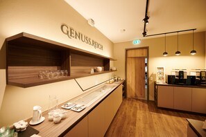 A modern kitchen with wooden shelves, a coffee station, and a counter with glassware. - Kucher's Genuss & Businesshotel (Darscheid)