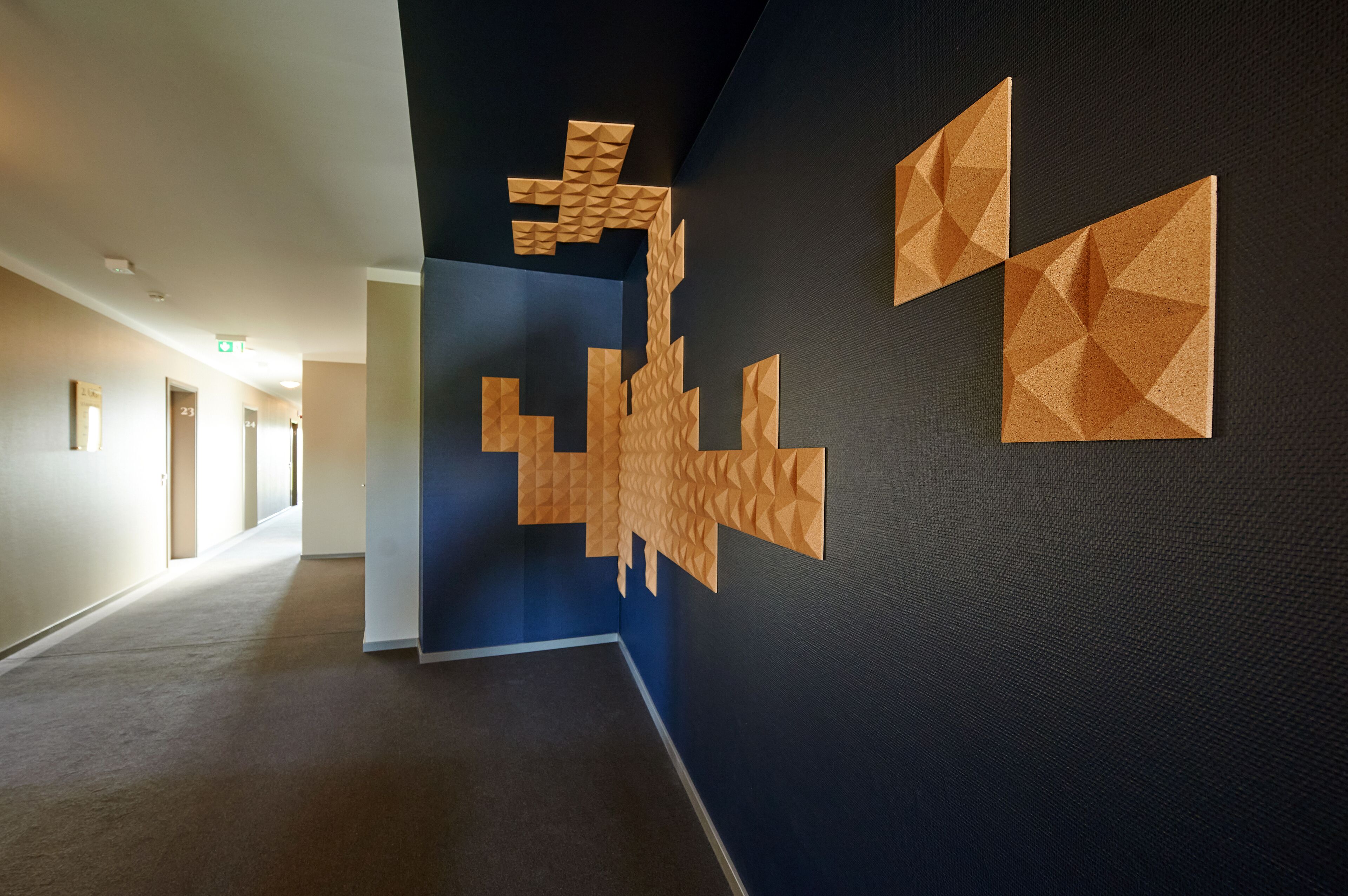 Ein Flur mit einer geometrischen Wandgestaltung und einer blauen Akzentwand.