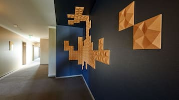 Ein Flur mit einer geometrischen Wandgestaltung und einer blauen Akzentwand.