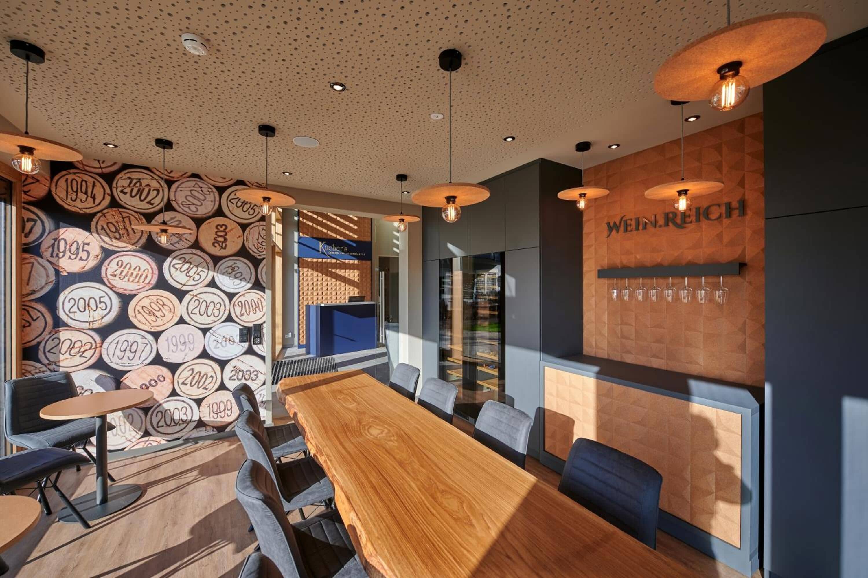 Ein moderner Konferenzraum mit einem Holztisch, Stühlen und einer Wand mit kreisförmigen Mustern.