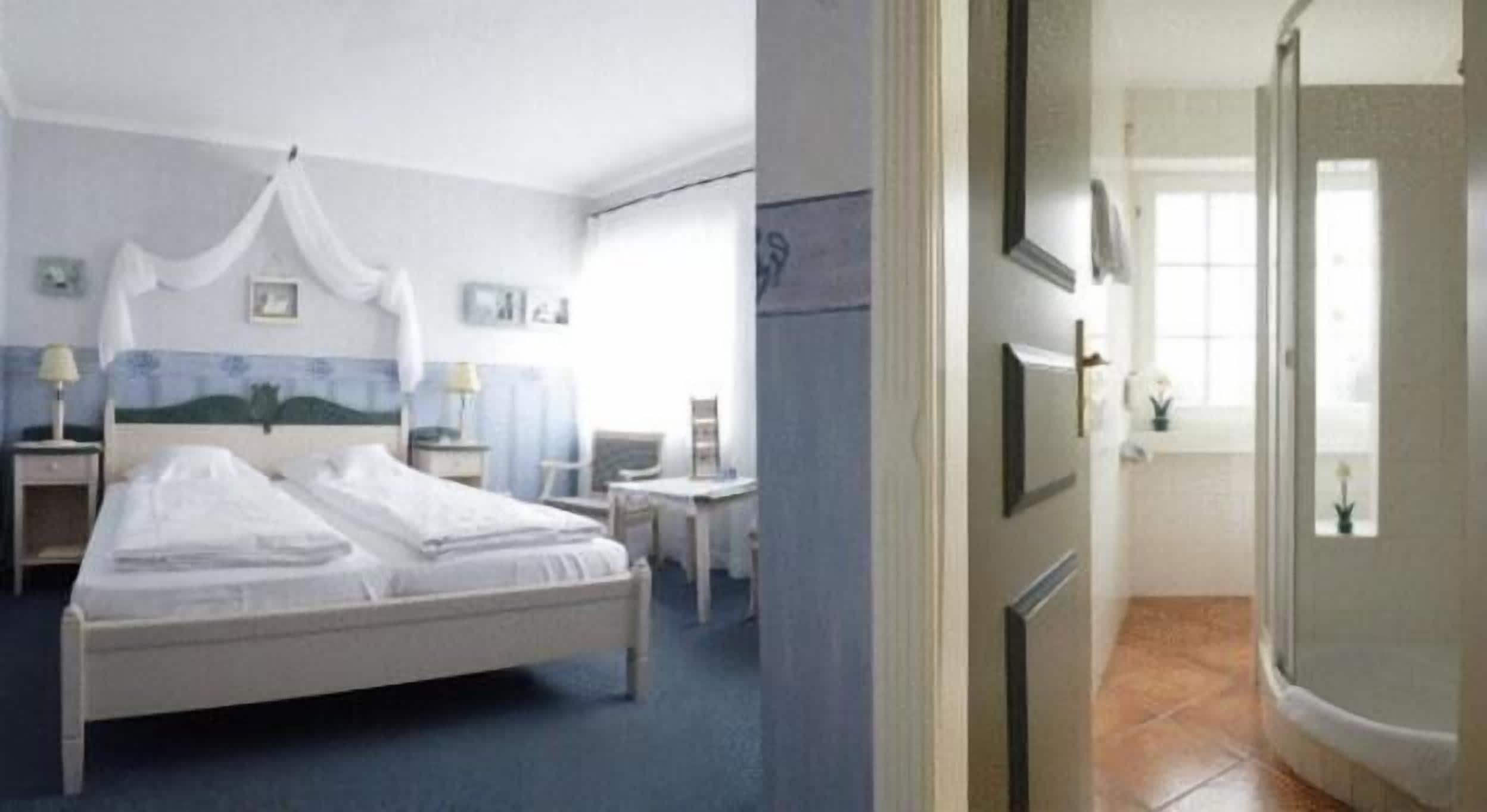 A hotel room with a bed, bedside tables, a chair, and a desk.