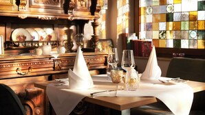 A dining table set with white napkins, clear glassware, and a decorative glass pitcher. - Kucher's Genuss & Businesshotel (Darscheid)
