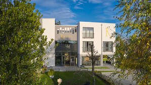 A modern building with the sign "Kucher’s" on the facade, featuring large windows and a flat roof. - Kucher's Genuss & Businesshotel (Darscheid)