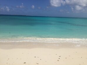 Une plage à l’eau turquoise et au sable blanc.