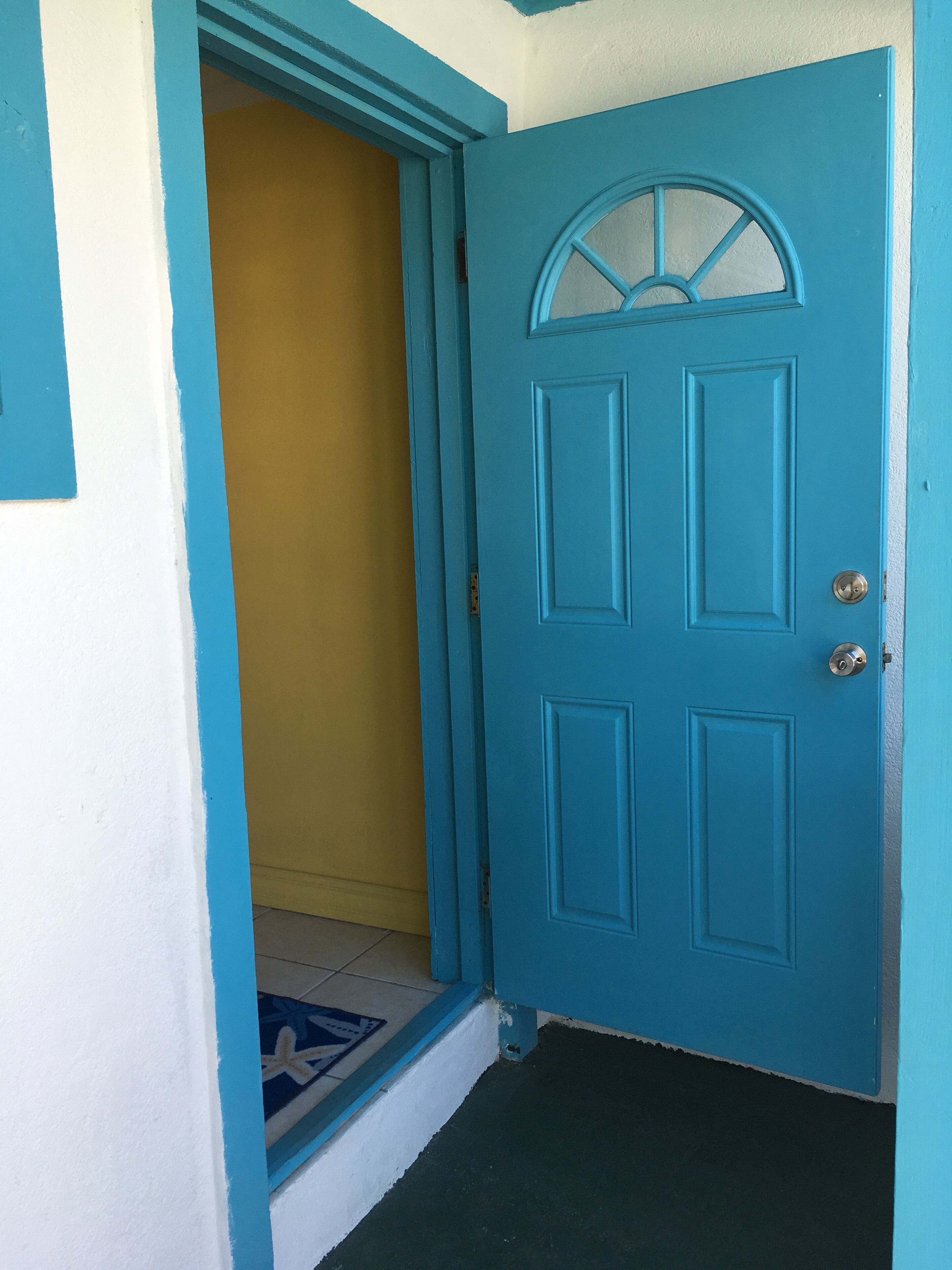 A blue door with a glass panel and a metal handle.
