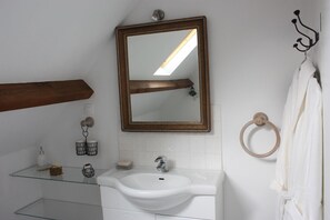 A bathroom with a white sink, a mirror, a towel ring, and a towel rack. - Chambre d'Hôtes Proche de Briare (Saint-Firmin-sur-Loire)