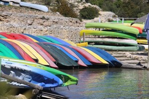 A row of colorful kayaks lined up at a rocky shore. - Chambre d'Hôtes Proche de Briare (Saint-Firmin-sur-Loire)