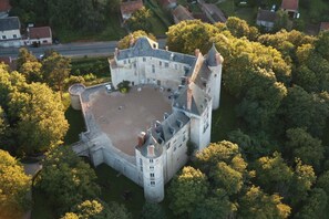 An aerial view of a castle with a large courtyard, surrounded by dense trees. - Chambre d'Hôtes Proche de Briare (Saint-Firmin-sur-Loire)