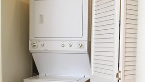 A compact laundry area with a front-loading washer and dryer, enclosed by white louvered doors. - 'Best Deal in Telluride' - Walk to Gondola & lift 8!     TBL #00111 (Telluride)