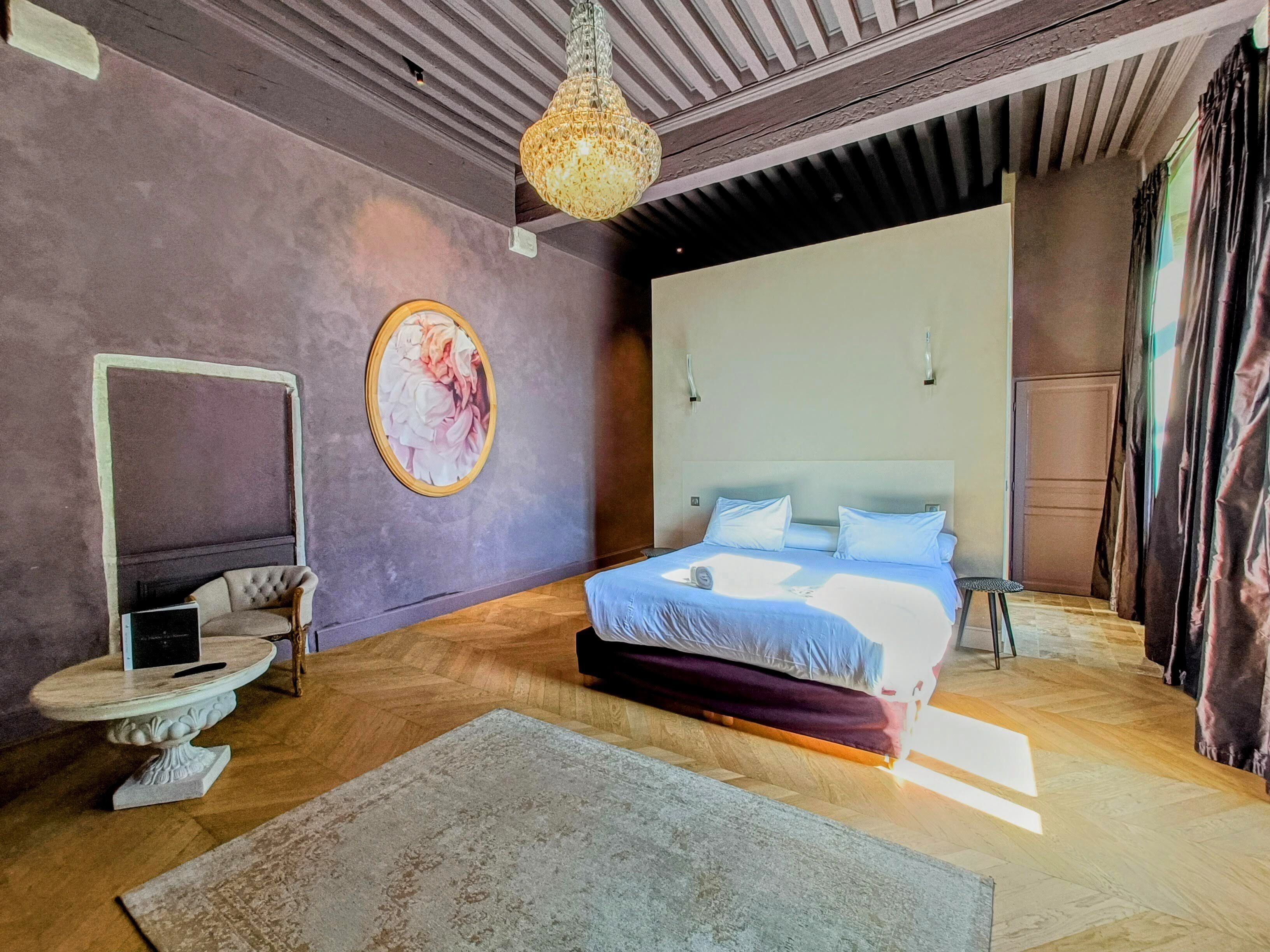 Una camera da letto moderna con un letto grande, uno specchio rotondo e un lampadario decorativo.