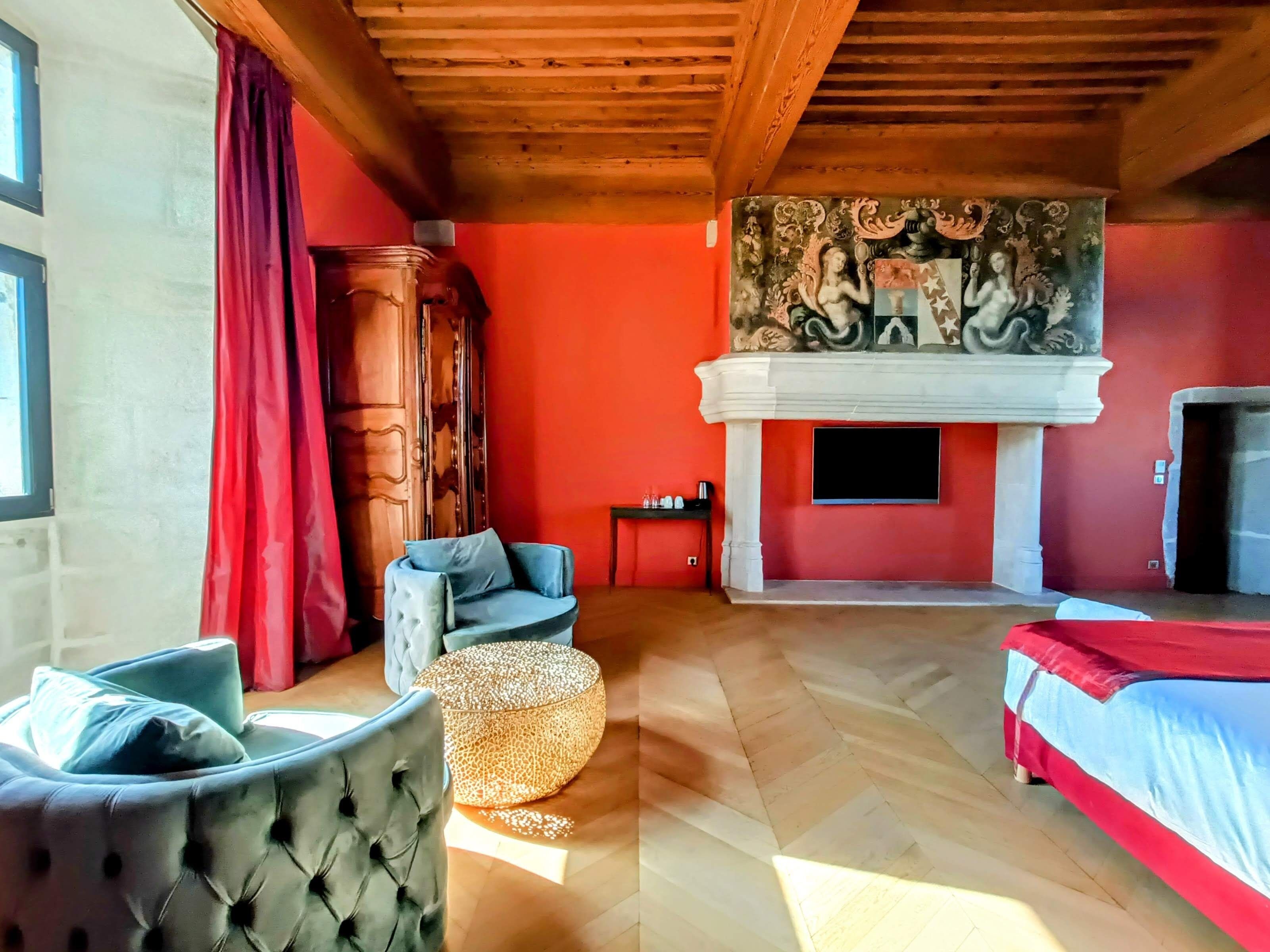 A room with a fireplace, a sofa, a bed, and a large mural on the wall.