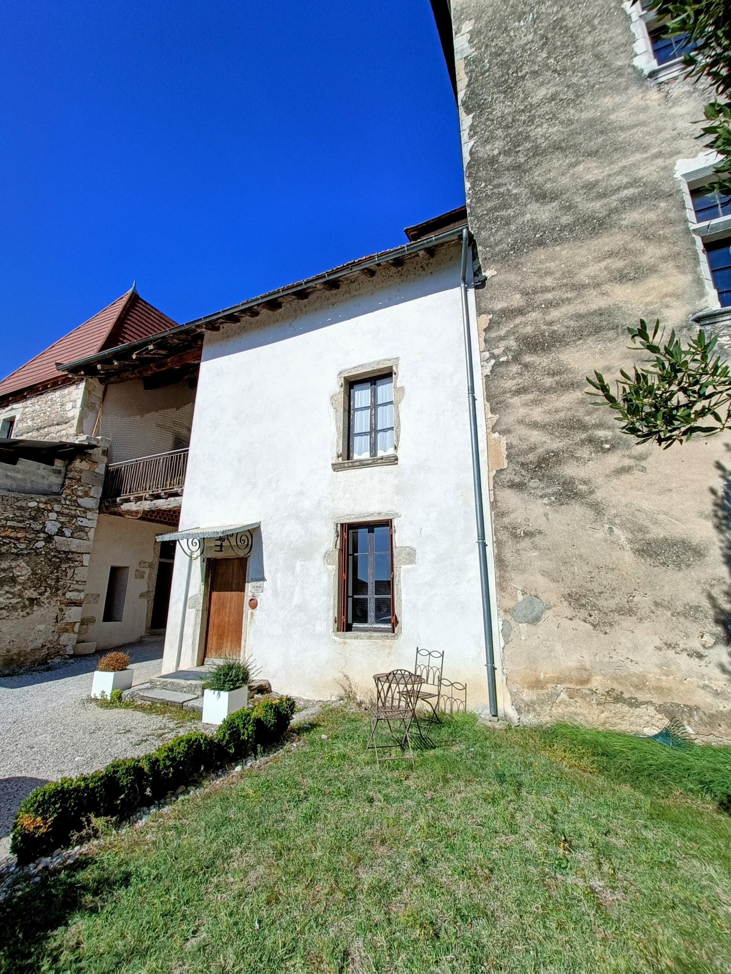 A two-story building with a stone facade and a red-tiled roof.