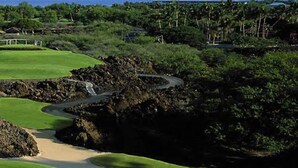A golf course with a winding path, lush green grass, and rocky terrain. - Stunning 4  bed, 3 1/2 bath Mauna Lani home near beach, golf (Waimea)