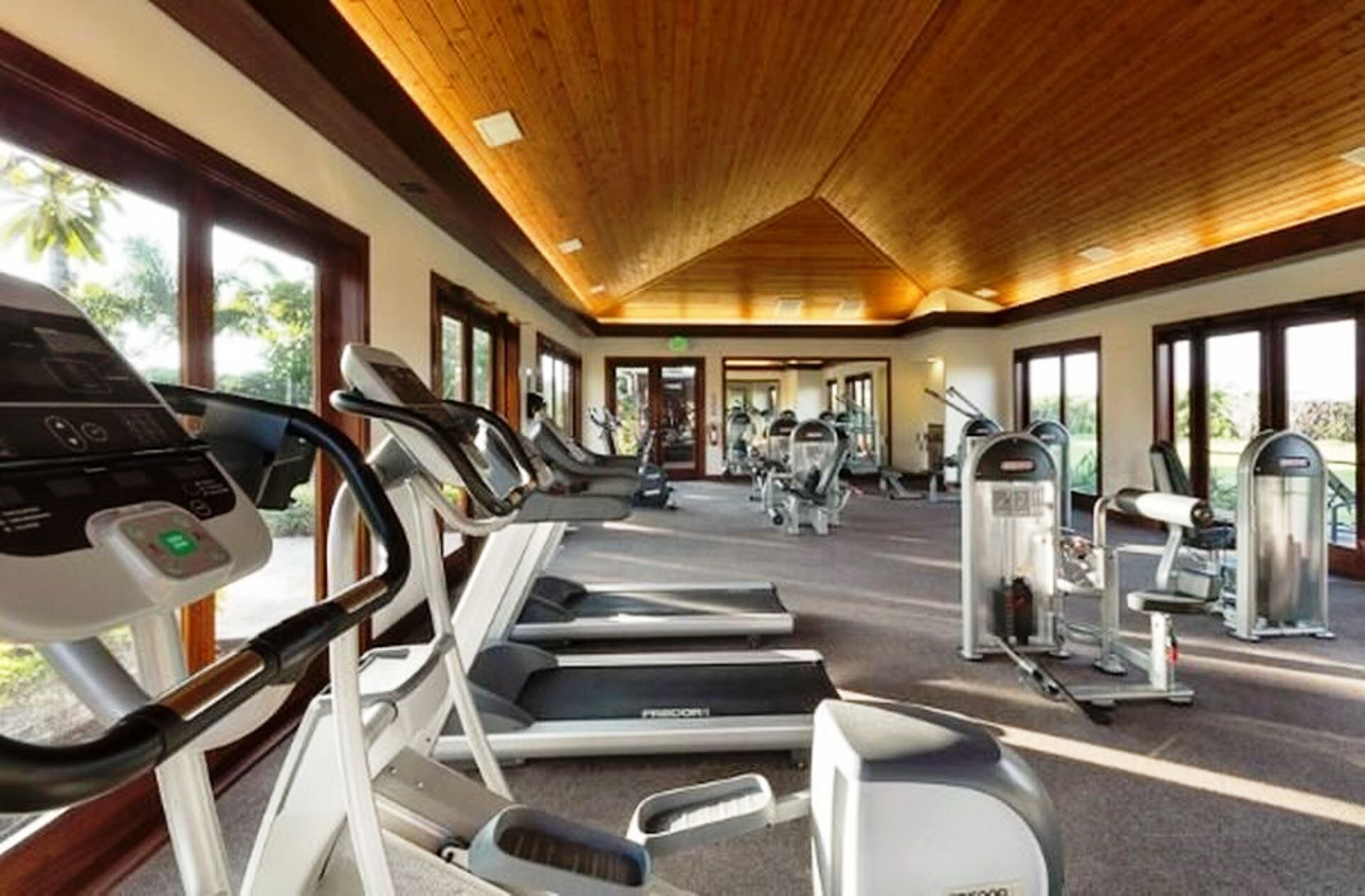 A gym with treadmills, elliptical machines, and weight equipment.