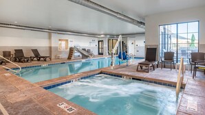 An indoor swimming pool with lounge chairs, a slide, and a view of the outside. - Comfort Inn & Suites Zion Park Area (Hurricane)