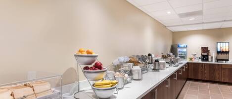 A breakfast bar with various food items and beverages.