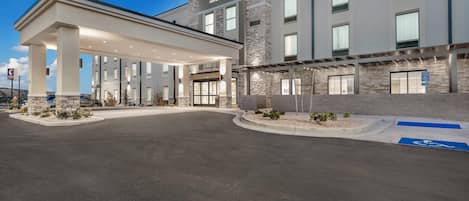 A Comfort Inn Suites hotel with a covered outdoor area, a parking lot, and a handicap-accessible entrance.