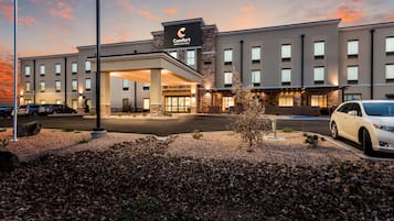 Stylish hotel with a flat roof and symmetrical facade, featuring evenly spaced windows and a covered walkway leading to the main entrance.