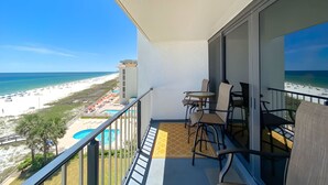 Ein Balkon mit Blick auf Strand, Pool und die Hotelgebäude.
