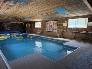 An indoor swimming pool with wooden walls, a mural, and a beach-themed sign. - Spokane Indoor Pool Home (Spokane)