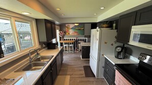 A modern kitchen with a built-in microwave, refrigerator, and sink. - Spokane Indoor Pool Home (Spokane)