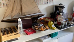 A kitchen counter with a world map, a coffee machine, condiments, and a small sailboat model. - Rosebarne Bed & Breakfast (Haverhill)