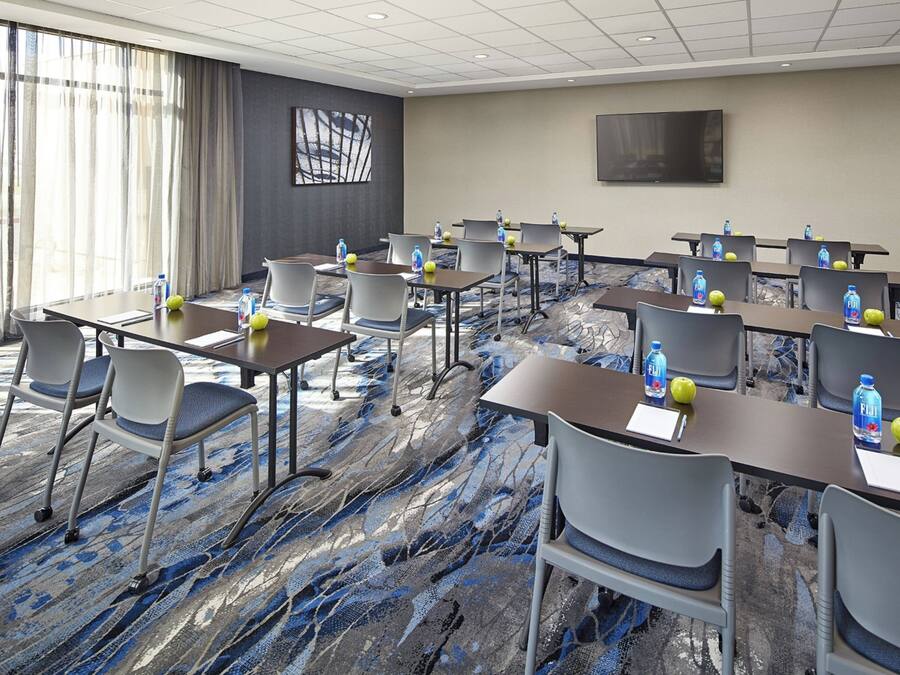 A conference room with tables, chairs, and water bottles.