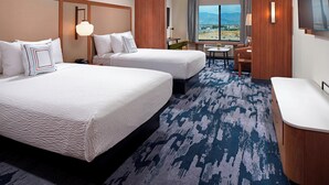 A hotel room with two beds, a desk, a chair, a TV, and a large window with a view. - Fairfield by Marriott Inn & Suites Indio Coachella Valley (Indio)