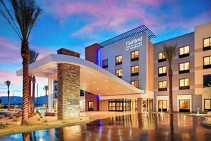 Een hotel met een modern design, met een opvallende ingang, een overdekte doorgang en een zwembad.