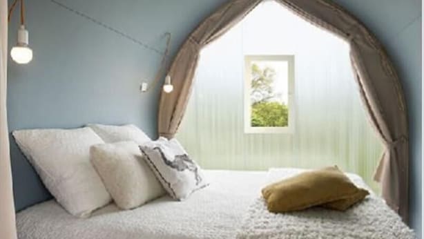 A bedroom with a bed, pillows, and a window with curtains. - Camping Saint Paul (Lyons-la-Foret)