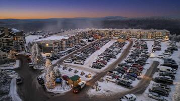 Ein verschneiter Parkplatz mit mehreren Gebäuden im Hintergrund.