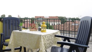 A balcony with a table set for two, featuring a yellow lantern and a basket of flowers. - Welc-oM Panoramic (Padova)