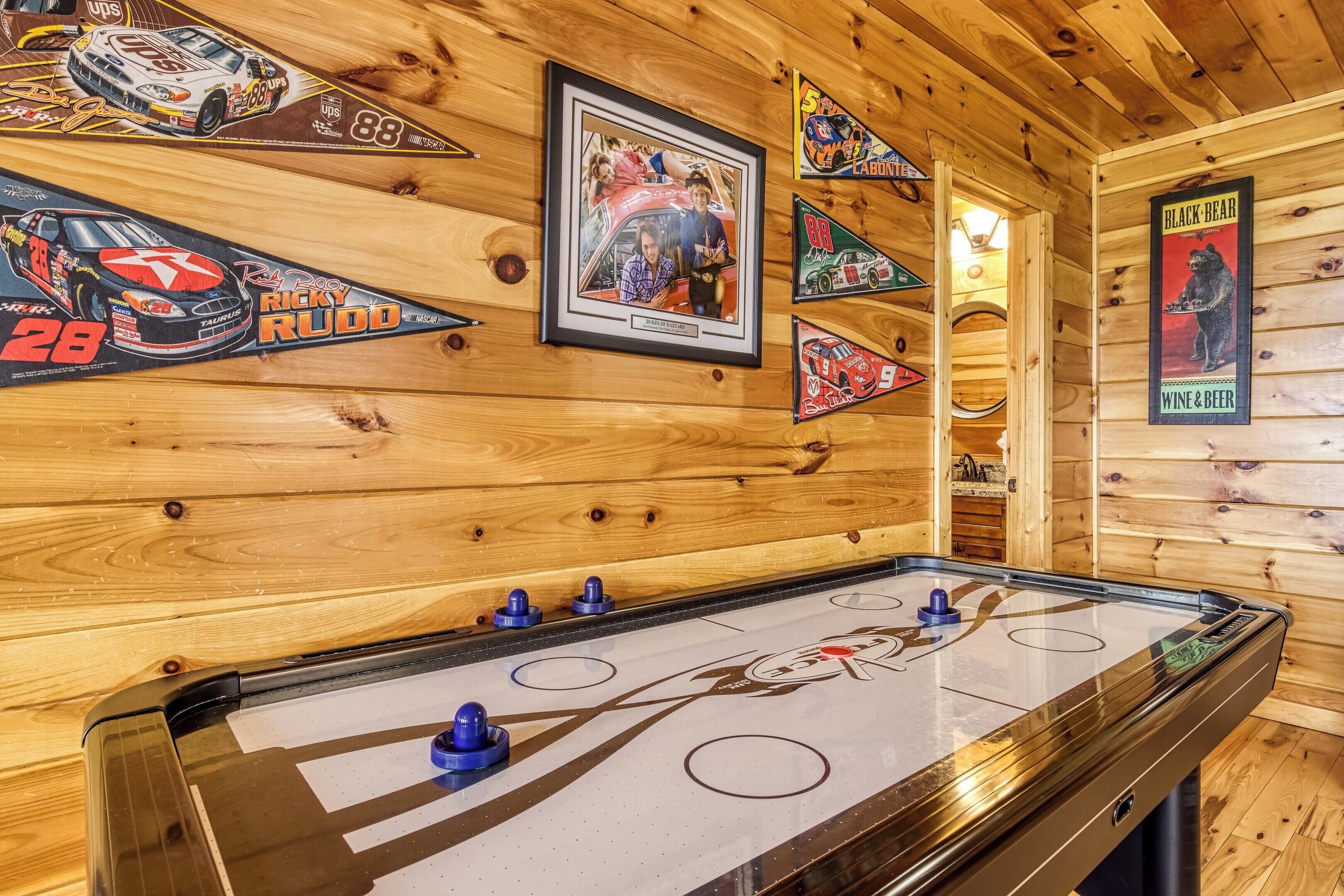 Un interior de madera con mesa de raspador, recuerdos enmarcados de NASCAR y un letrero de Black Bear.