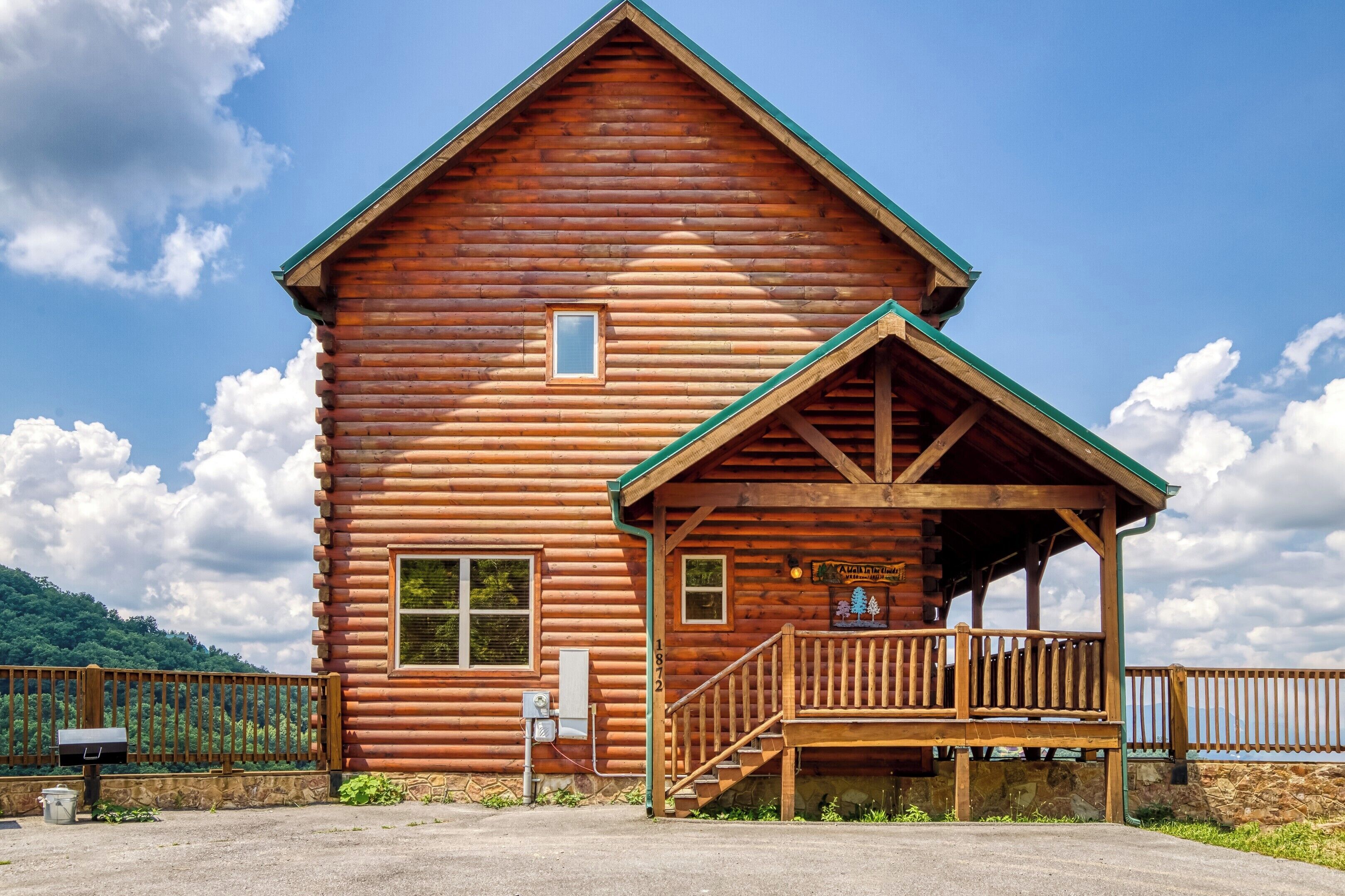 Une cabane en bois avec une véranda et un petit escalier menant à l’entrée.