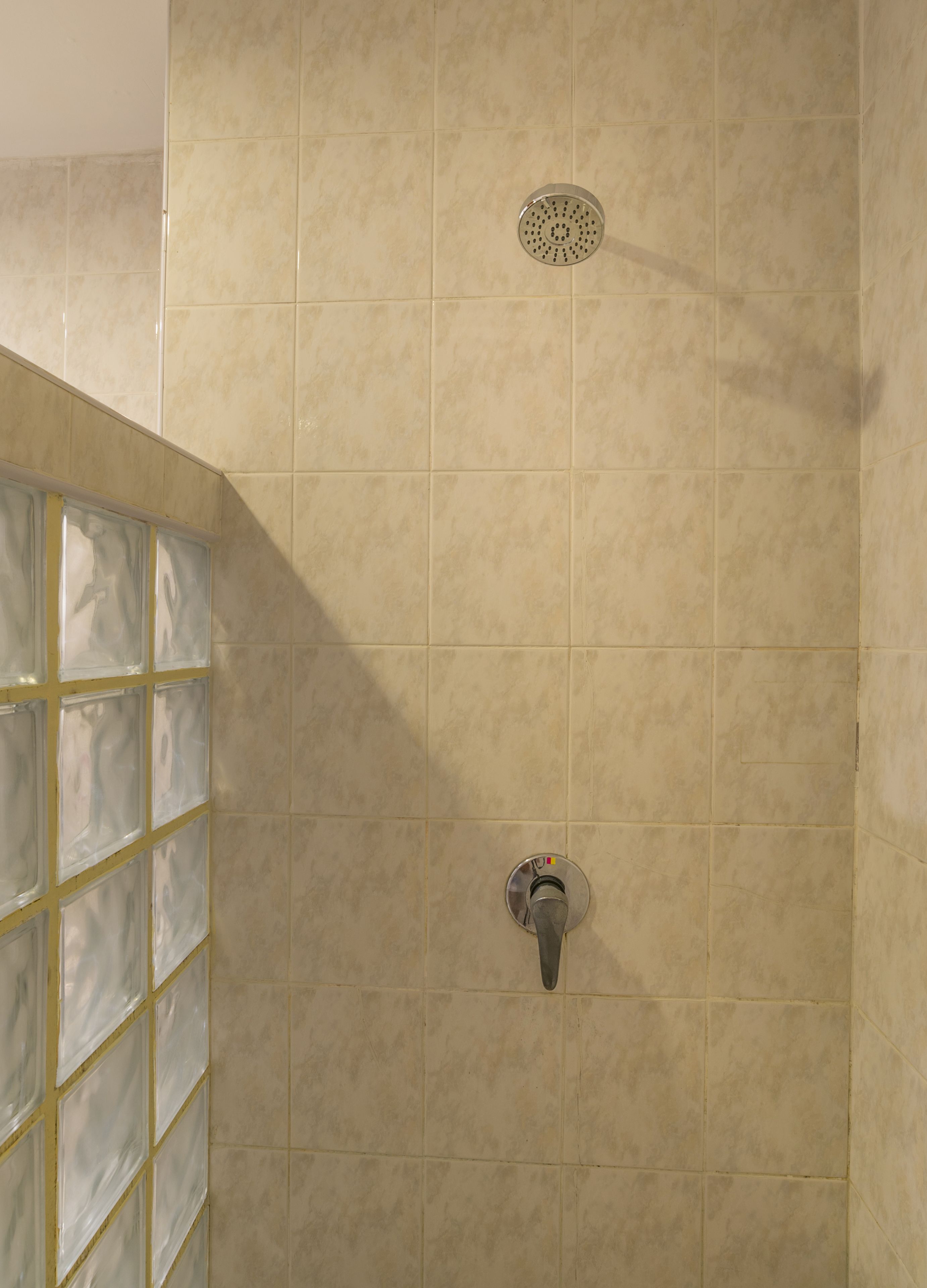 A shower with a glass door and a wall-mounted control panel.