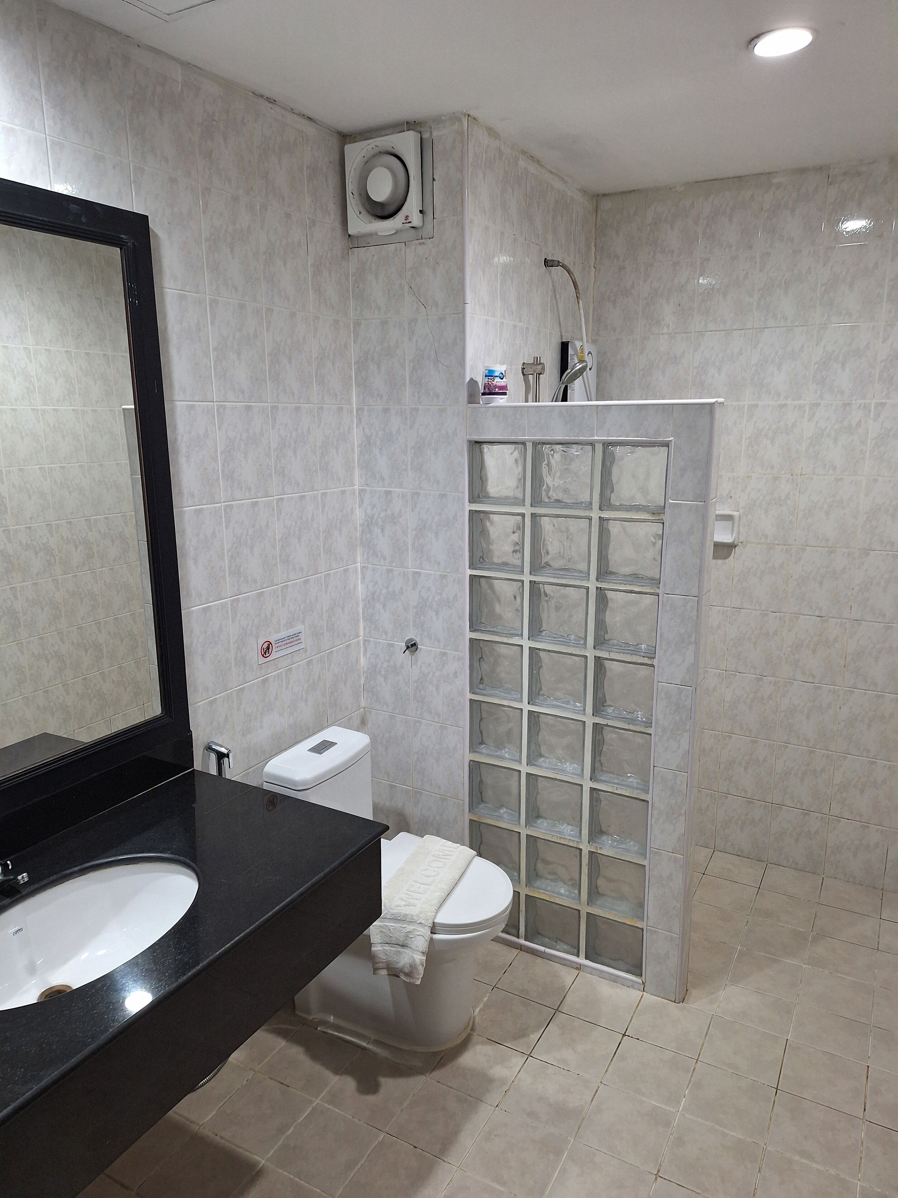 A modern bathroom with a black sink, white toilet, and a glass shower enclosure.