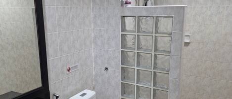 A modern bathroom with a black sink, white toilet, and a glass shower enclosure.