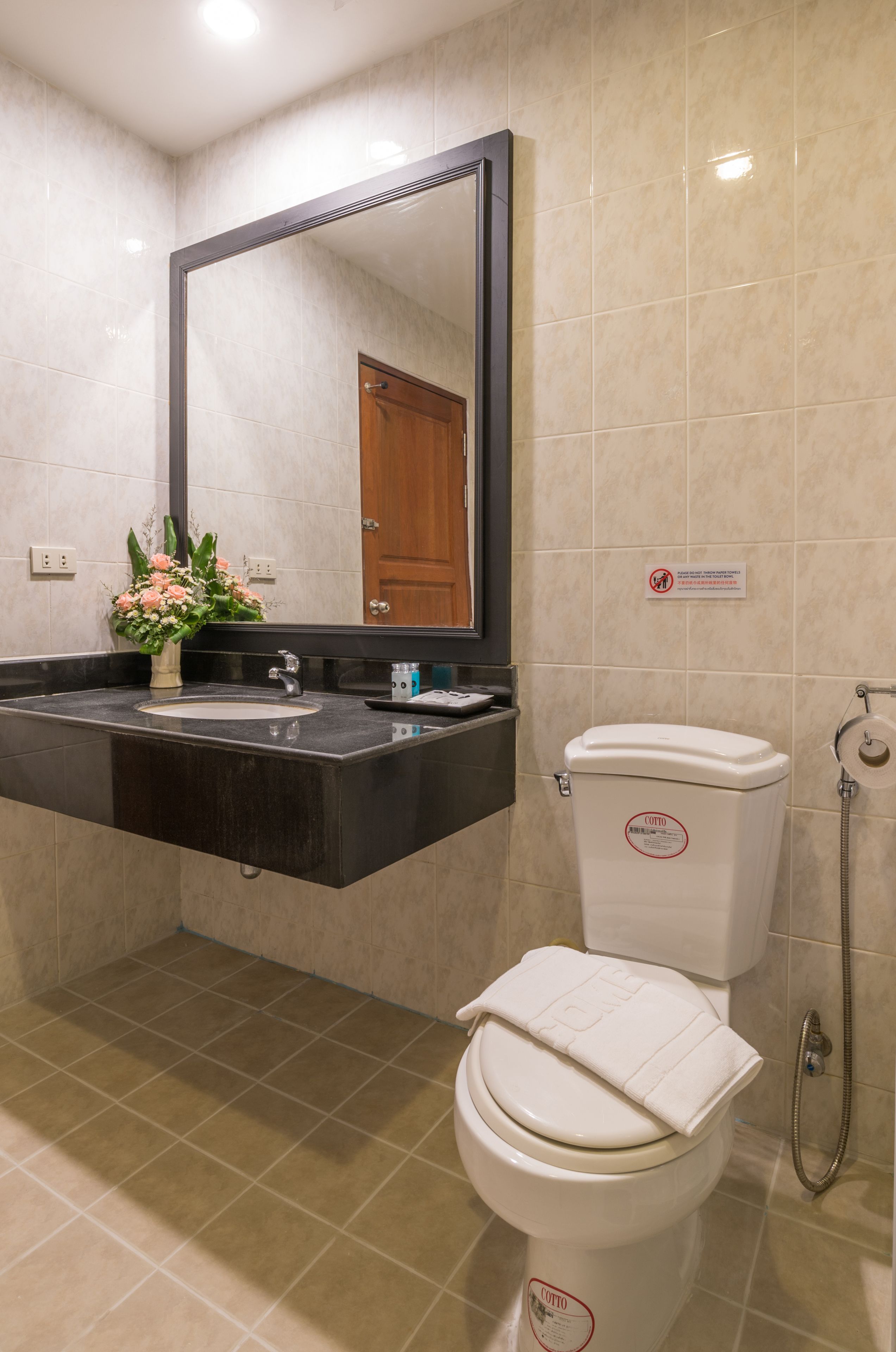 A bathroom with a sink, mirror, toilet, and shower.