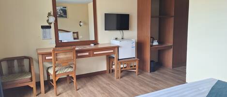 Une chambre d’hôtel équipée d’un lit, d’un bureau, d’une chaise, d’une armoire et d’un téléviseur.