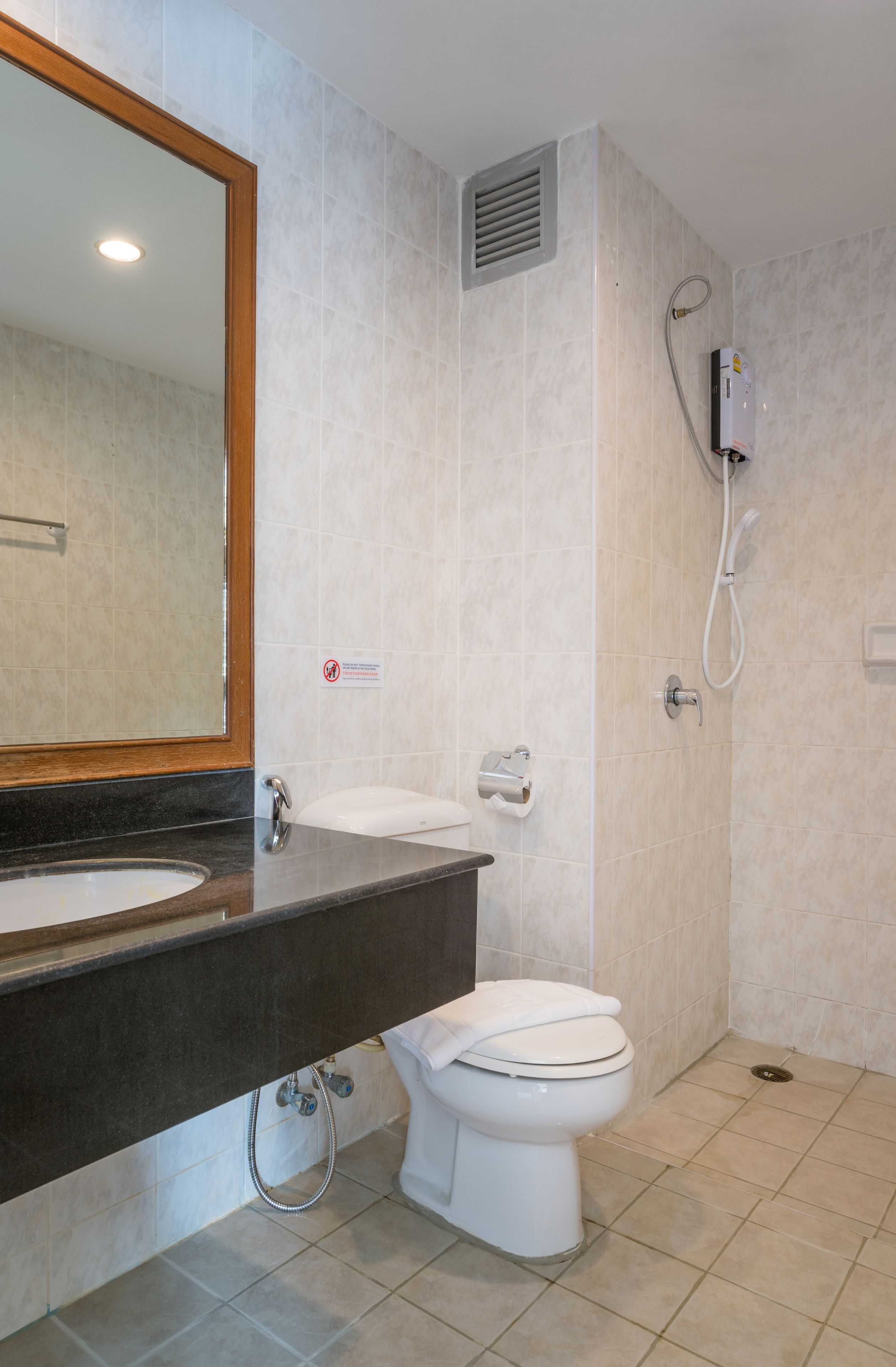 Une salle de bain avec un lavabo, des toilettes et une douche.