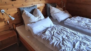 A wooden cabin bedroom with two beds, each with white bedding and pillows. - Premium Chalet a. d.Piste in ski u. Hiking area BELALP with panoramic views (Blatten)