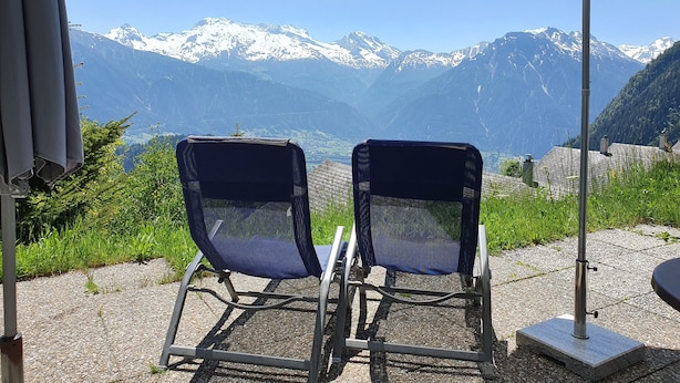 Two outdoor chairs with a mountain view, a gravel path, and a white umbrella. - Premium Chalet a. d.Piste in ski u. Hiking area BELALP with panoramic views (Blatten)