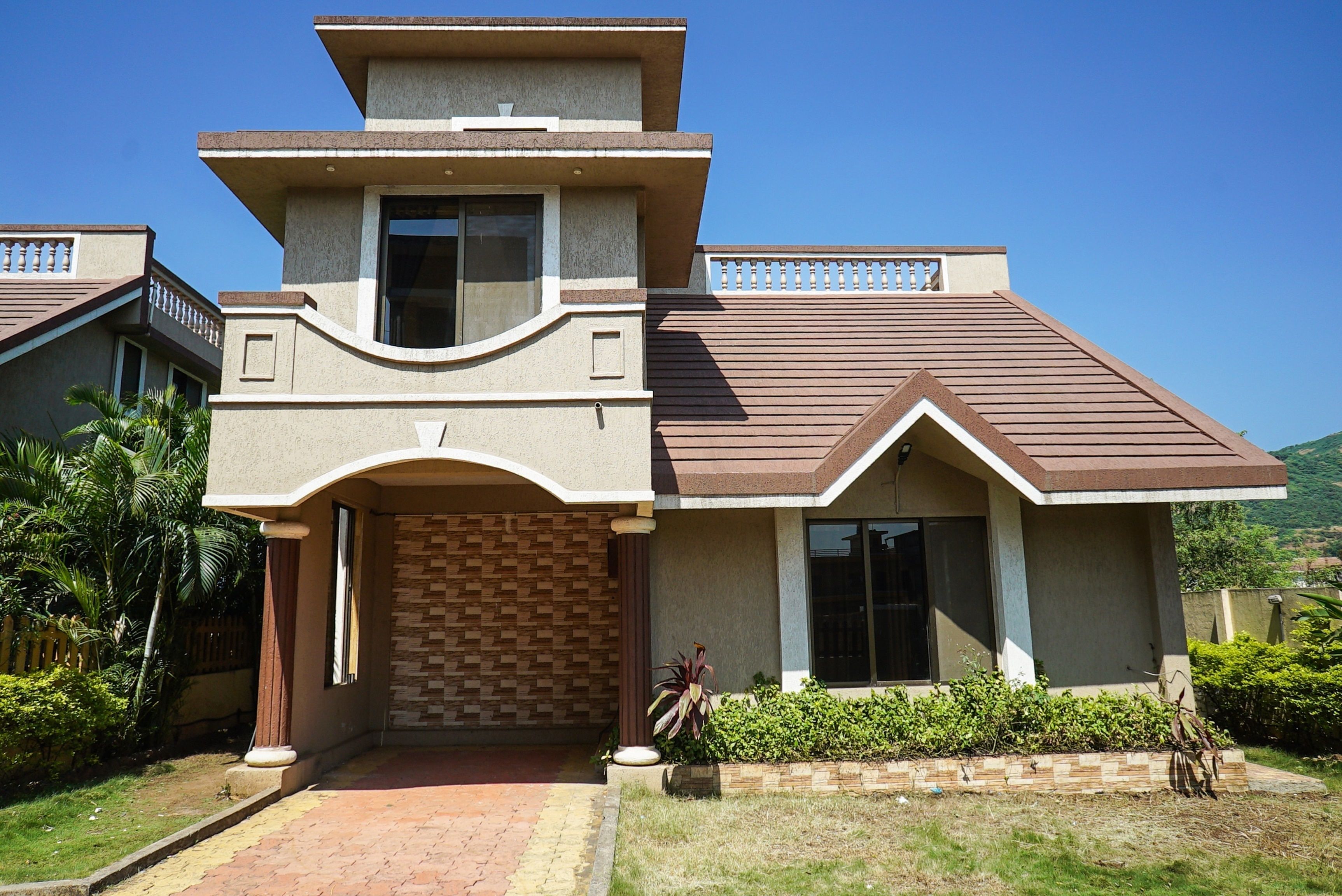 A modern two-story house with a brick facade, a central entrance, and a small porch.