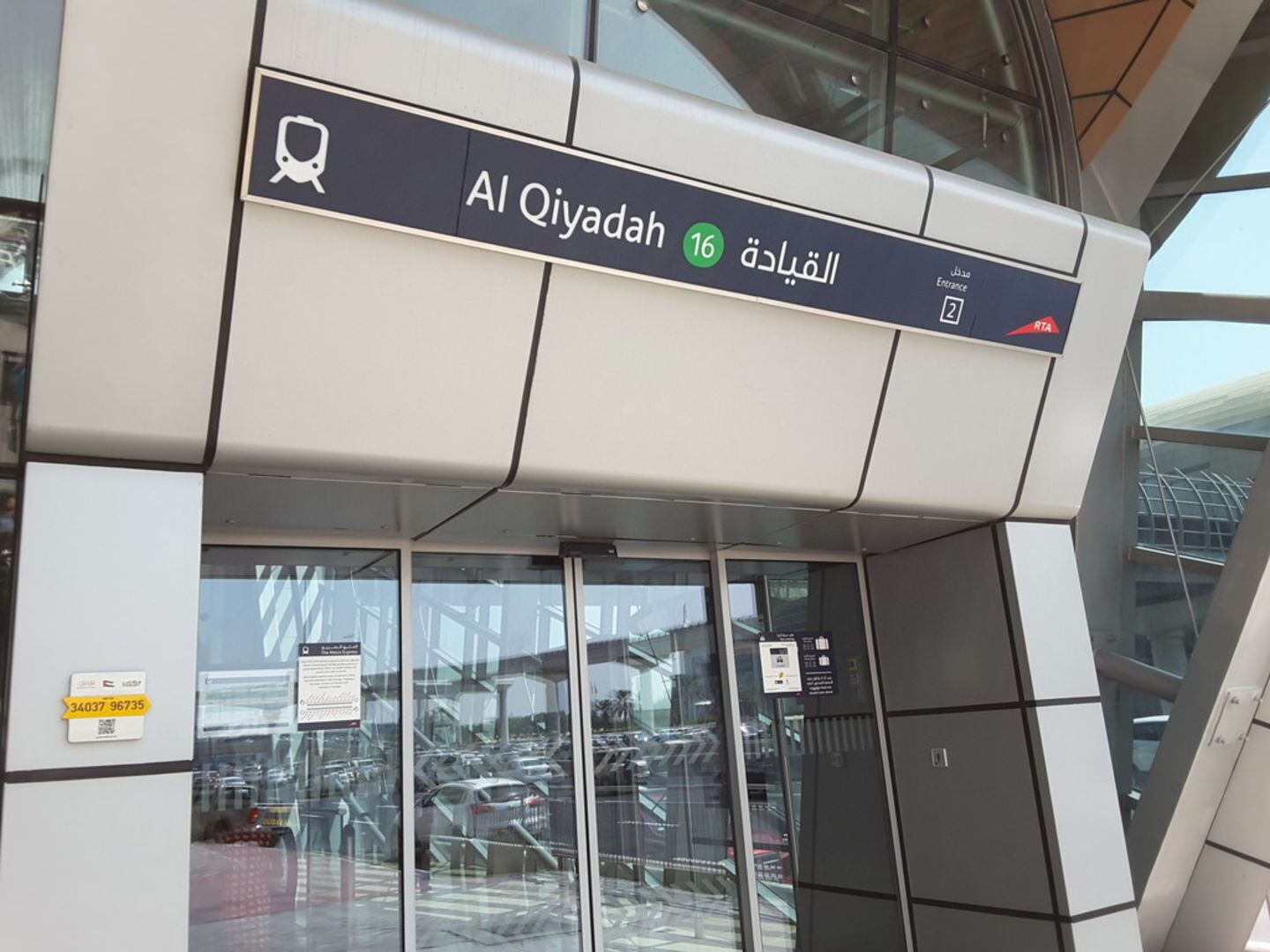 Une entrée moderne d’un immeuble, avec une enseigne indiquant « Al Qiyada 16 ».